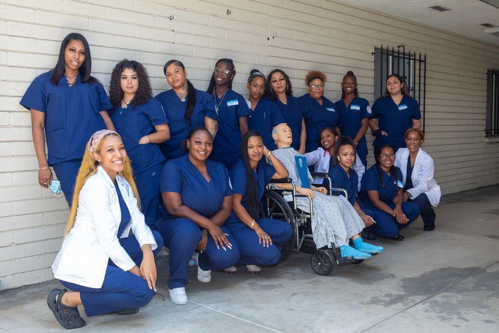 Mahoney school group in blue scrubs outside a classroom