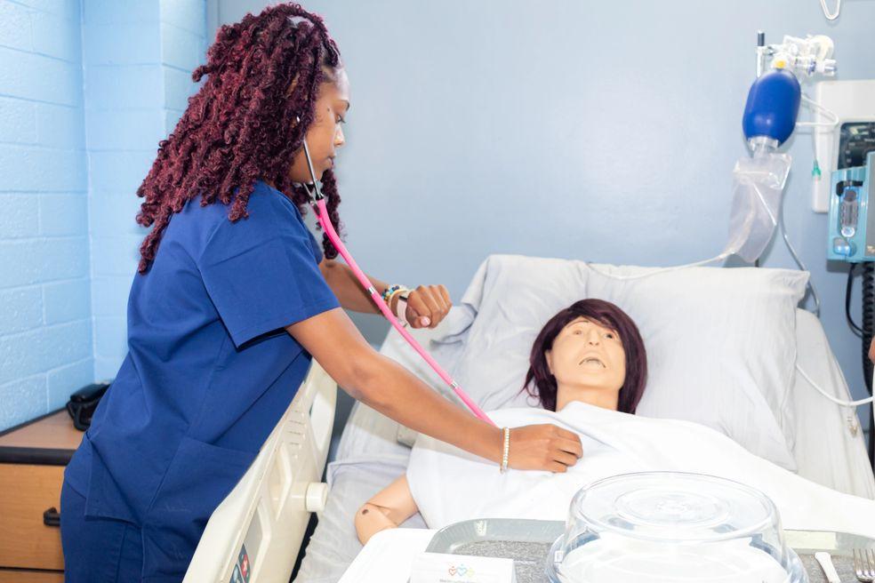 Mahoney student practicing patient-care skills with a training mannequin